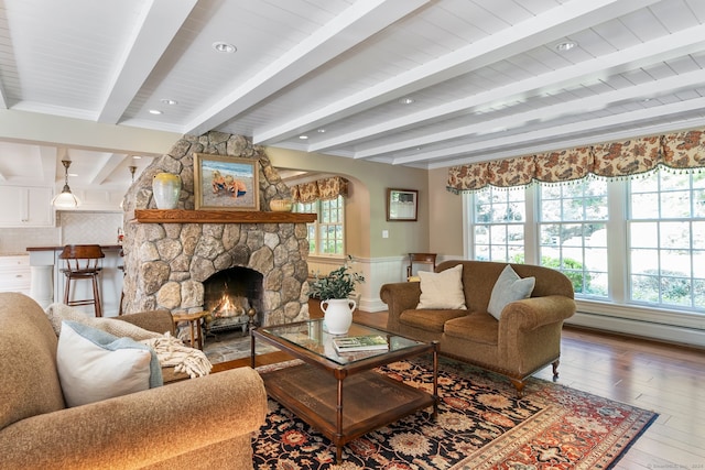 living room with beam ceiling, hardwood / wood-style flooring, and a fireplace