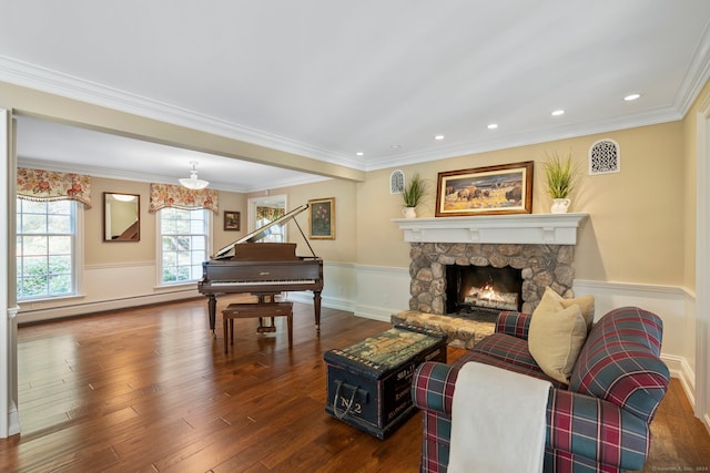 living room featuring a baseboard radiator, hardwood / wood-style flooring, a fireplace, and crown molding