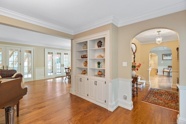 interior space with light hardwood / wood-style flooring, ornamental molding, and french doors