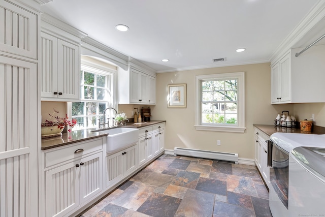 kitchen featuring a baseboard heating unit, white cabinetry, sink, separate washer and dryer, and ornamental molding