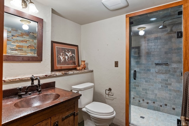 bathroom with a shower with door, vanity, and toilet