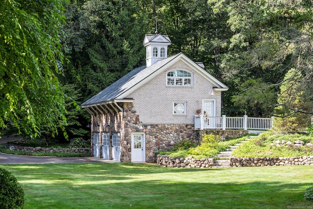 rear view of house with a lawn, a garage, and a deck