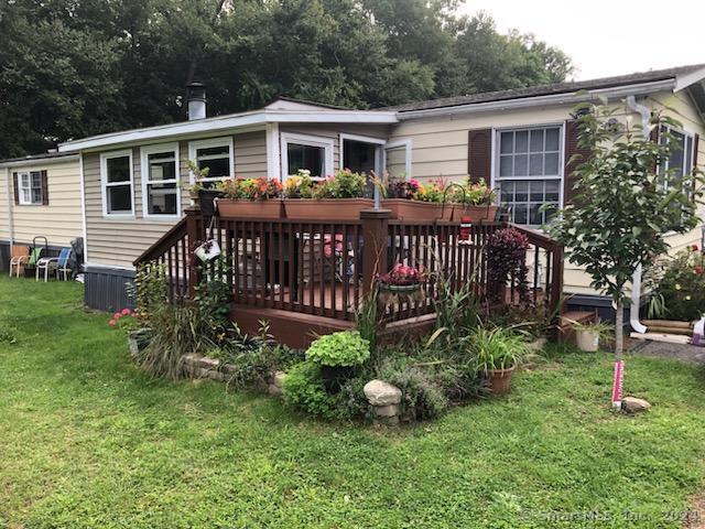 rear view of house featuring a wooden deck and a yard