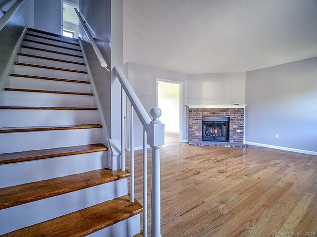 stairs featuring a fireplace and wood-type flooring