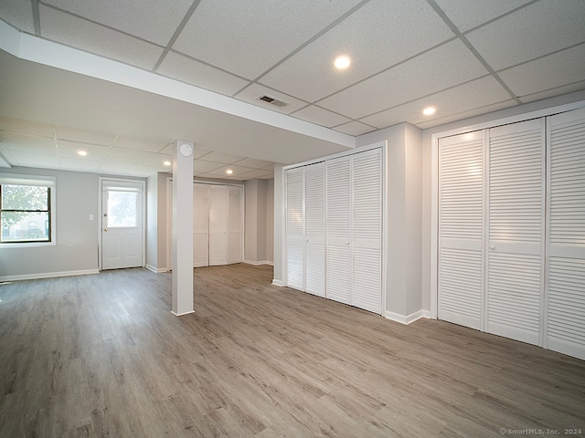 basement featuring hardwood / wood-style flooring and a drop ceiling