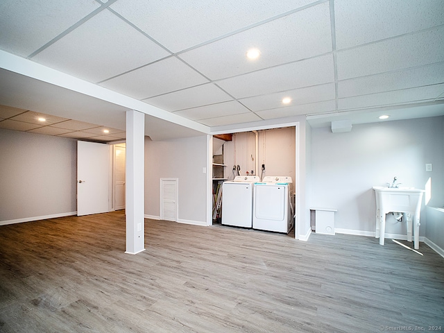 basement featuring washer and dryer, hardwood / wood-style floors, and a drop ceiling