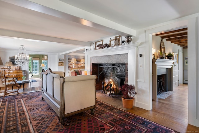 44 S St, Roxbury, CT 06783 - living room with wood finished floors, beamed ceiling, a baseboard heating unit, a warm lit fireplace, and a notable chandelier