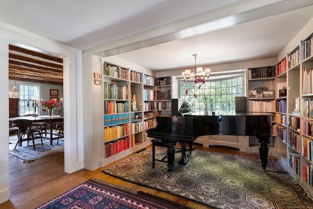 44 S St, Roxbury, CT 06783 - living area with baseboards, wall of books, a chandelier, and wood finished floors