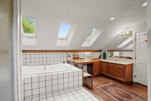 bathroom with tile patterned flooring, a textured ceiling, vanity, and lofted ceiling