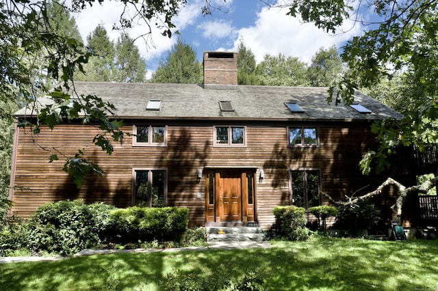 exterior space featuring a chimney and a front lawn