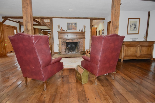 living room featuring beam ceiling, a fireplace, and hardwood / wood-style flooring