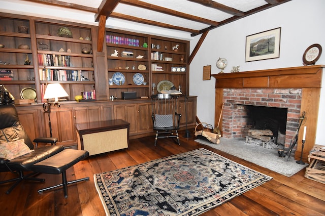 home office featuring dark wood-style floors, beam ceiling, and a fireplace