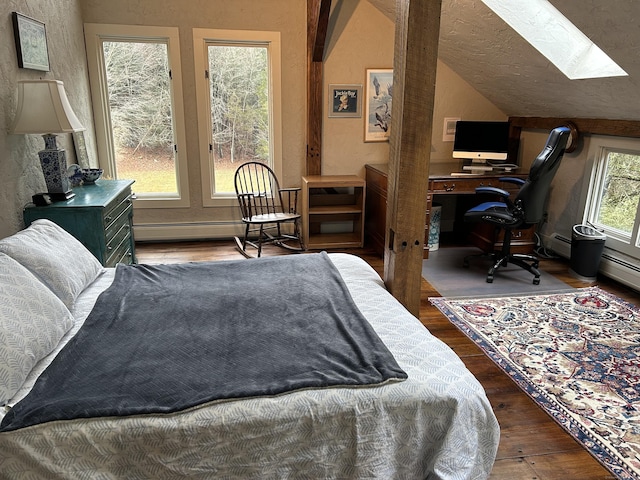 bedroom with a textured ceiling, wood-type flooring, baseboard heating, and lofted ceiling with skylight