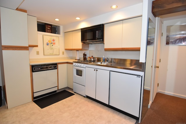 kitchen featuring white appliances, stainless steel counters, a sink, and recessed lighting