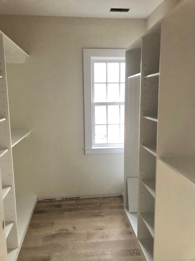 walk in closet with hardwood / wood-style floors