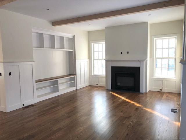 unfurnished living room with beamed ceiling, built in shelves, and dark hardwood / wood-style flooring