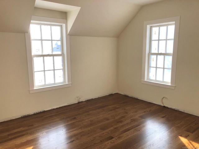 additional living space with dark hardwood / wood-style flooring and vaulted ceiling