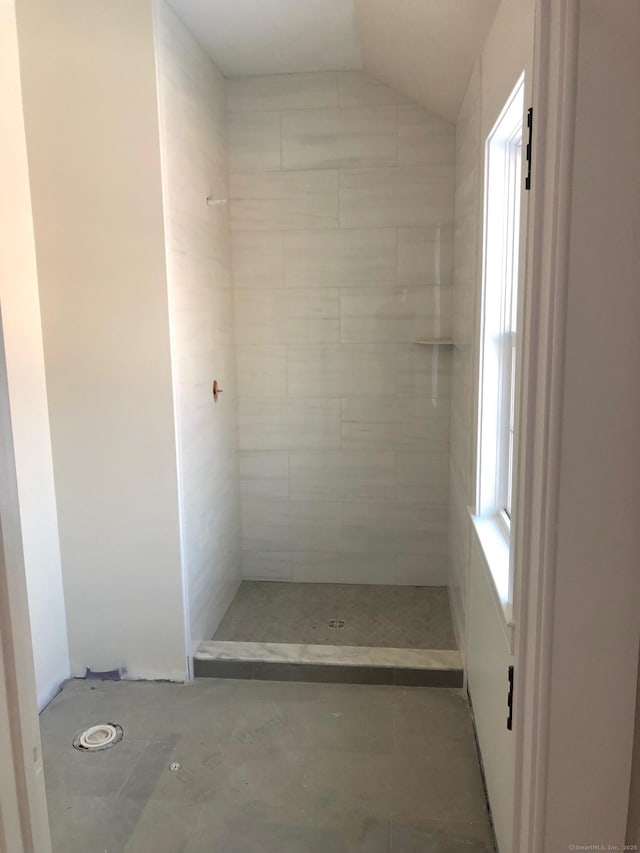 bathroom with a shower and vaulted ceiling