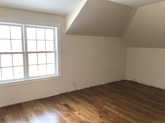 bonus room with vaulted ceiling and dark hardwood / wood-style floors