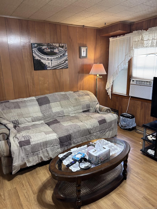 living area with wooden walls, cooling unit, and wood finished floors