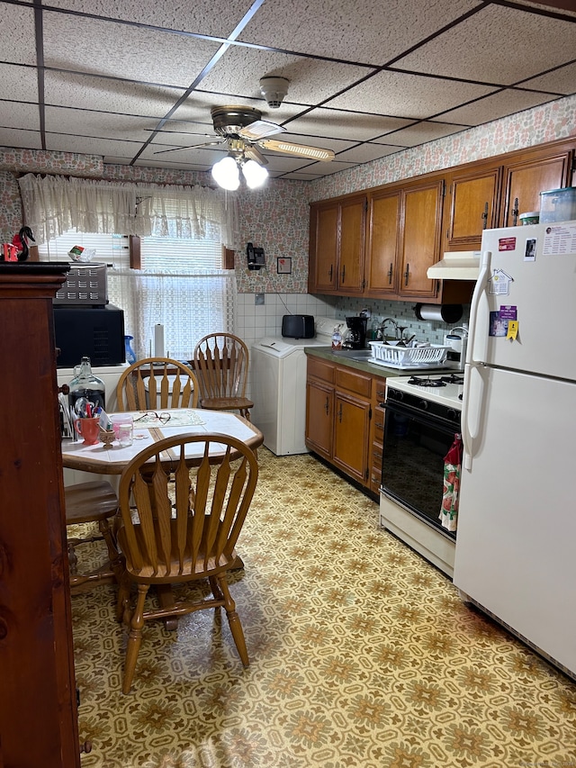 kitchen with a drop ceiling, white appliances, backsplash, ceiling fan, and washer / clothes dryer