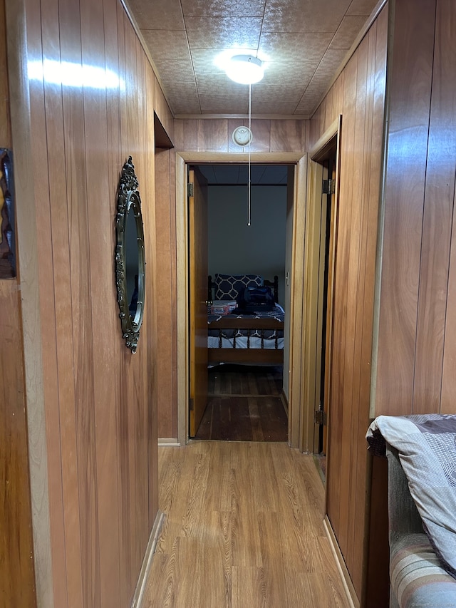 hallway with hardwood / wood-style floors and wooden walls