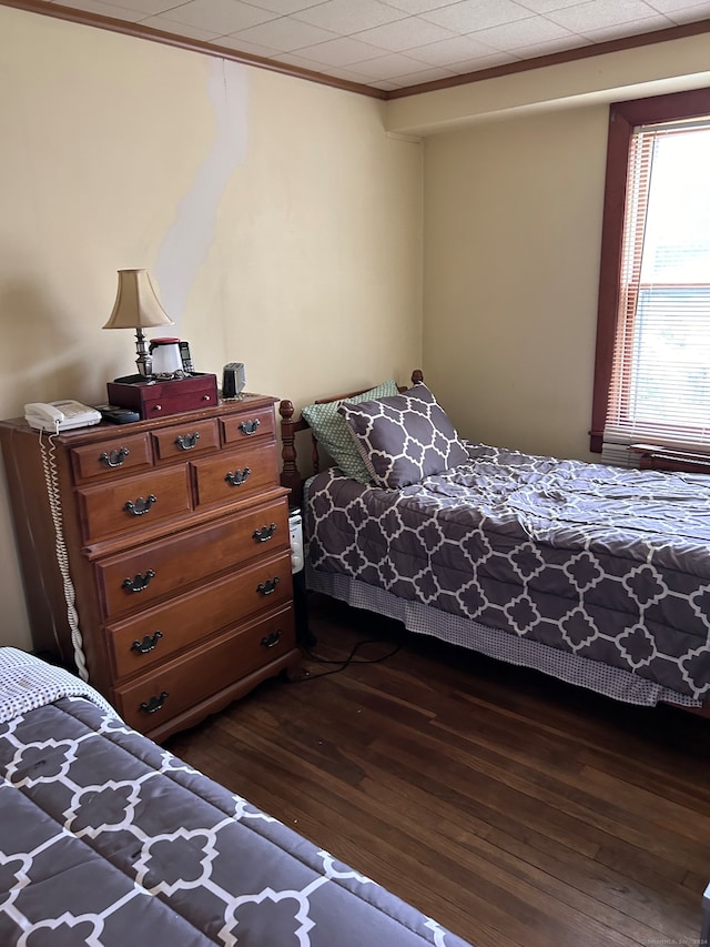 bedroom featuring crown molding and dark hardwood / wood-style floors