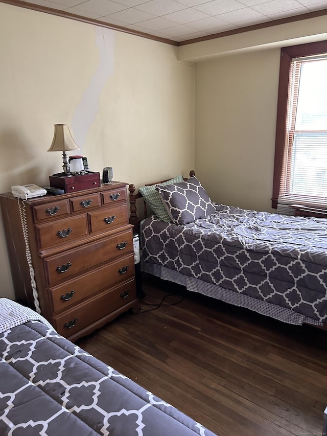 bedroom with dark wood-style floors and ornamental molding