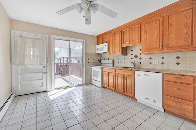 kitchen with light stone countertops, backsplash, white appliances, sink, and baseboard heating