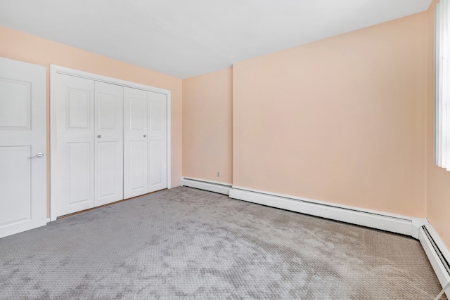 unfurnished bedroom featuring carpet floors, a closet, and baseboard heating