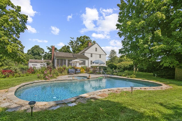 view of pool featuring a lawn and a patio