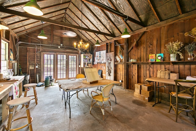 dining space with wooden walls, beamed ceiling, concrete flooring, and high vaulted ceiling