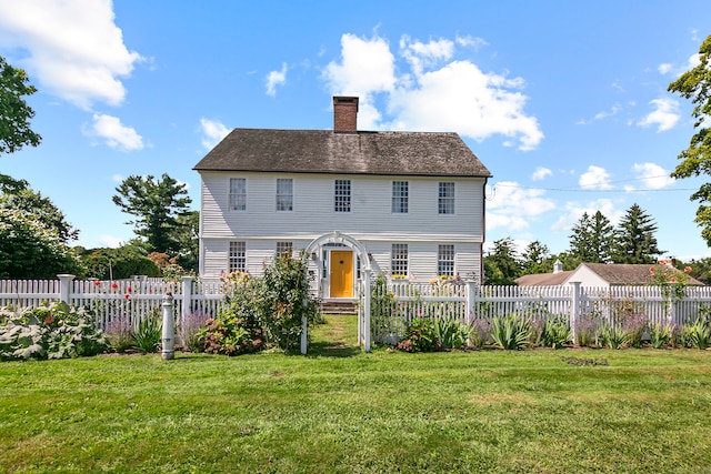 colonial inspired home featuring a front lawn