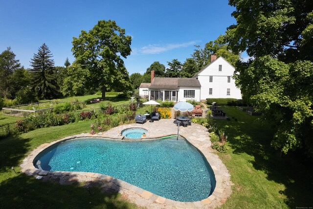 view of swimming pool featuring an in ground hot tub, a yard, and a patio area