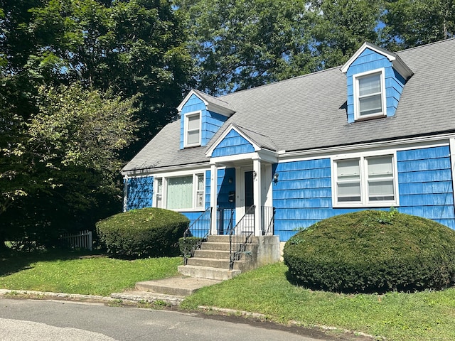 cape cod house featuring a front lawn