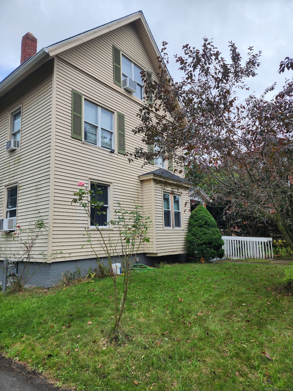 view of side of home with a yard and cooling unit