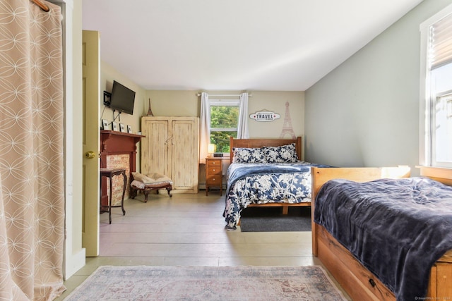 bedroom featuring vaulted ceiling and light wood-type flooring