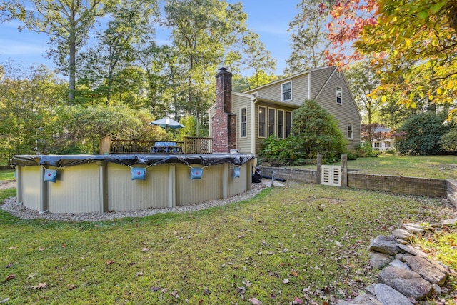 view of yard with a sunroom and a covered pool