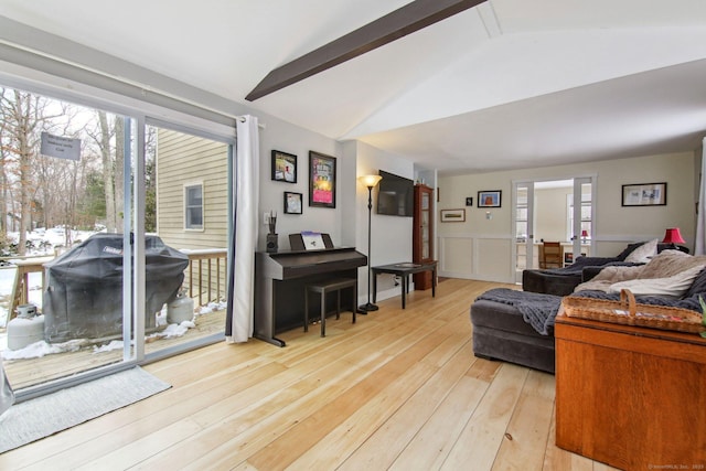 living room with lofted ceiling, a healthy amount of sunlight, and light hardwood / wood-style floors