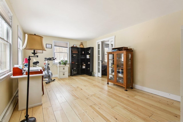 interior space featuring baseboard heating and light wood-type flooring