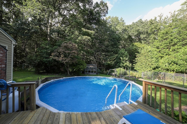 view of pool with a lawn and a deck