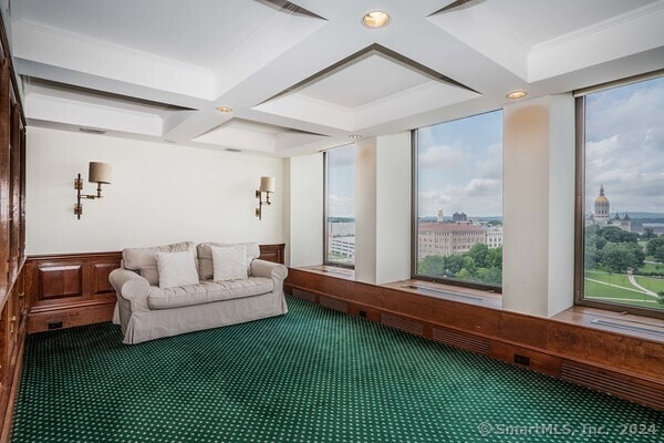 carpeted living room with ornamental molding, beamed ceiling, coffered ceiling, and plenty of natural light