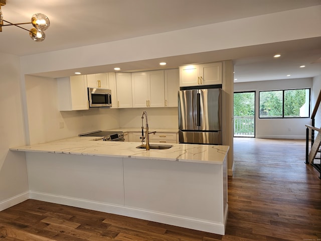 kitchen featuring kitchen peninsula, sink, stainless steel appliances, and white cabinets