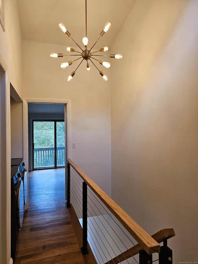 hall featuring an inviting chandelier, dark wood-type flooring, and high vaulted ceiling