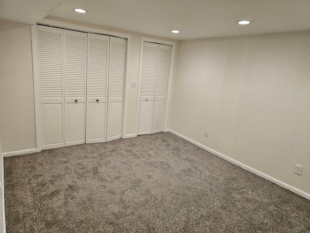 unfurnished bedroom featuring two closets and carpet flooring