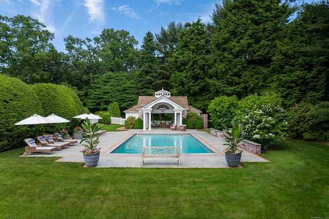 view of pool with a patio area and a lawn