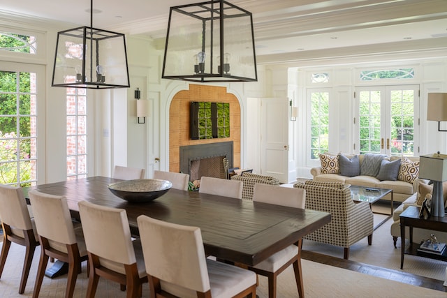 dining area featuring crown molding, french doors, hardwood / wood-style flooring, and an inviting chandelier