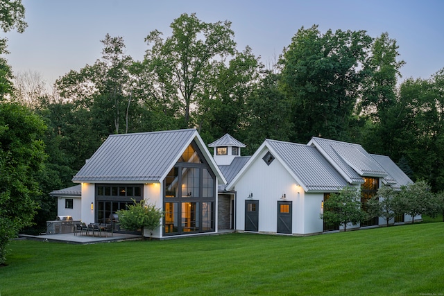 back house at dusk with a lawn