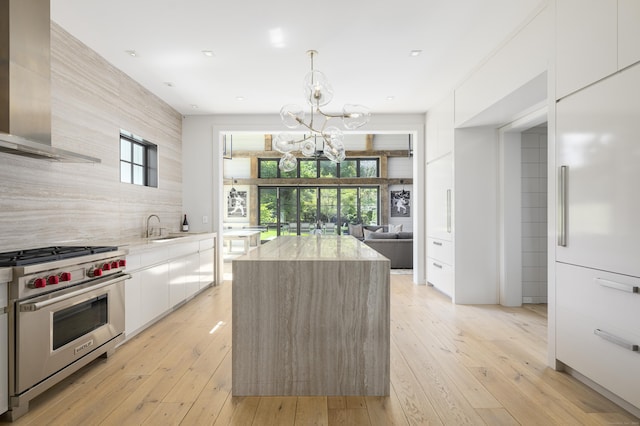 865 Hollow Tree Ridge Rd, Darien, CT 06820 - kitchen featuring designer range, wall chimney exhaust hood, modern cabinets, a chandelier, and a sink