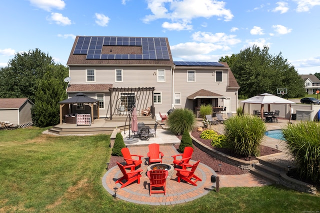 rear view of house with a patio, a yard, solar panels, and a gazebo